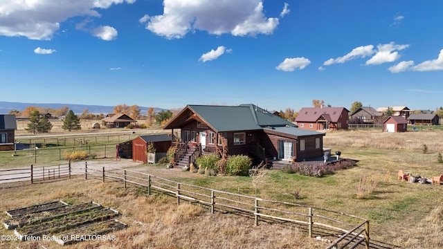 view of front of house with a rural view and an outdoor structure