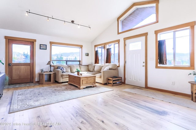 entryway with light hardwood / wood-style flooring, high vaulted ceiling, and track lighting