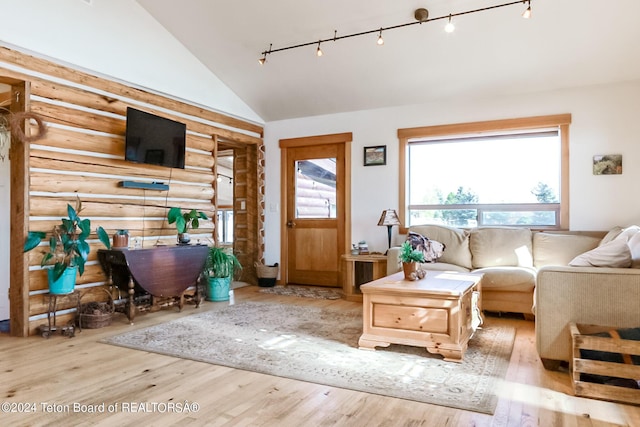 interior space featuring rail lighting, light hardwood / wood-style floors, and lofted ceiling