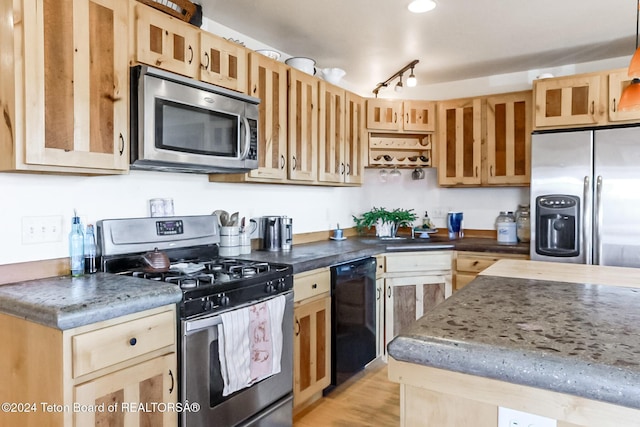 kitchen with sink, light brown cabinets, light hardwood / wood-style flooring, pendant lighting, and appliances with stainless steel finishes