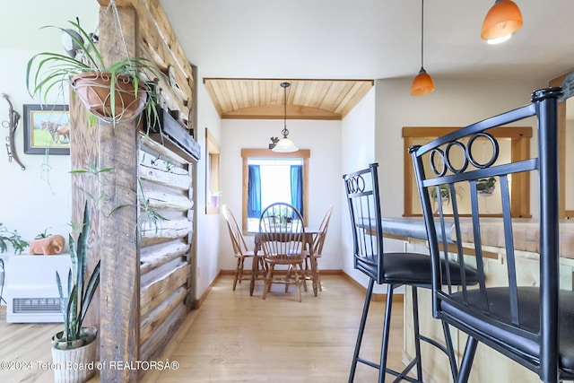 dining area with light wood-type flooring and lofted ceiling