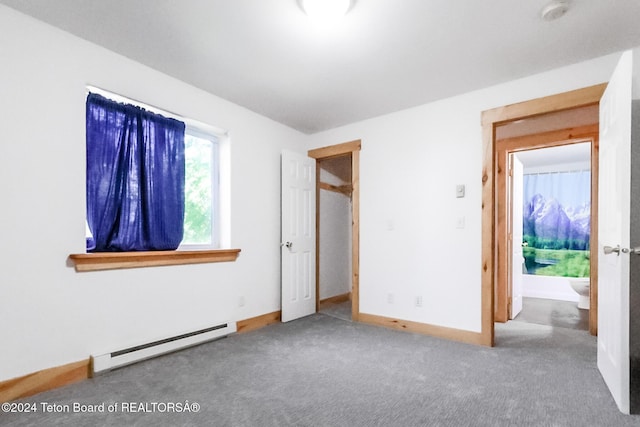 unfurnished bedroom with baseboard heating and carpet floors