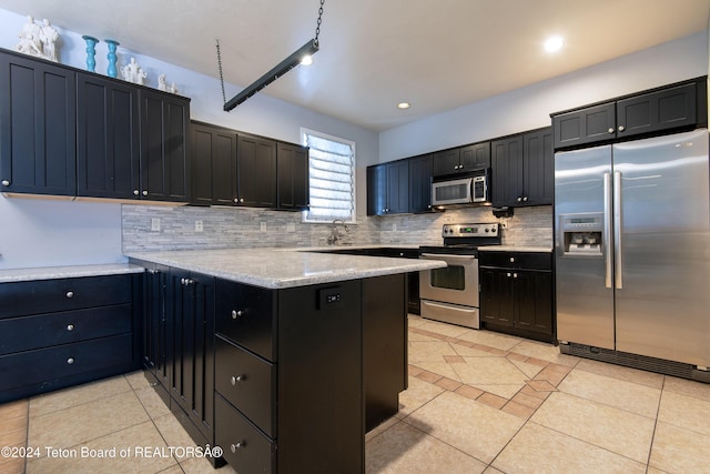 kitchen with light stone countertops, appliances with stainless steel finishes, kitchen peninsula, and light tile patterned floors