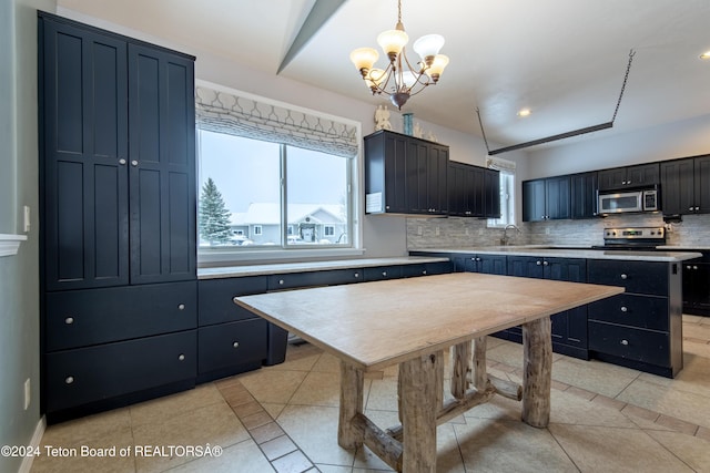 kitchen featuring appliances with stainless steel finishes, light tile patterned floors, an inviting chandelier, a kitchen island, and hanging light fixtures