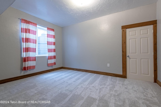 carpeted spare room with a textured ceiling