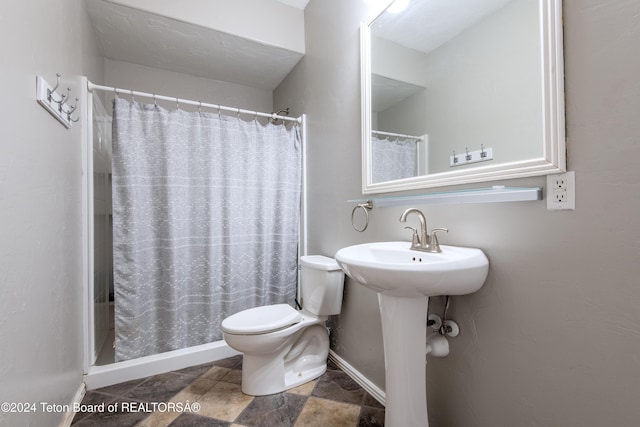 bathroom featuring toilet and curtained shower