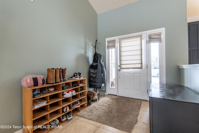 tiled foyer featuring vaulted ceiling