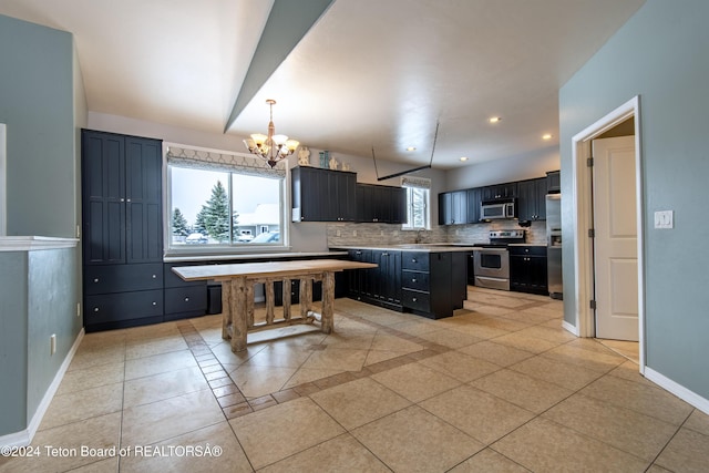 kitchen featuring an inviting chandelier, tasteful backsplash, a kitchen island, light tile patterned floors, and appliances with stainless steel finishes