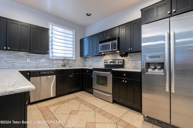 kitchen featuring light tile patterned floors, sink, appliances with stainless steel finishes, and tasteful backsplash