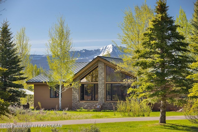 view of home's exterior with a mountain view and a yard