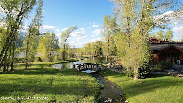 exterior space with a water view and a lawn