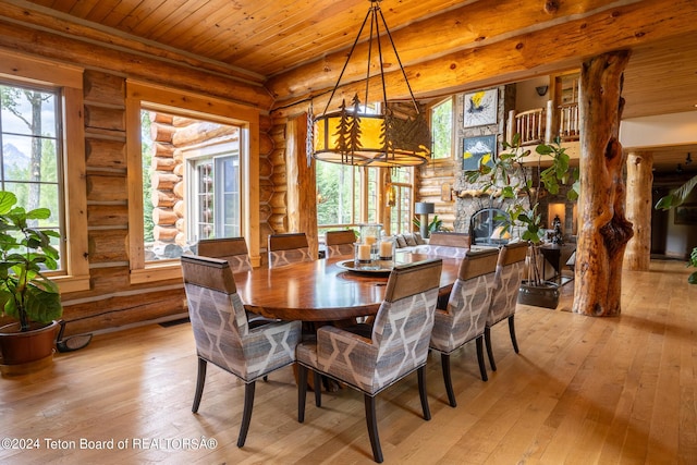 dining room featuring light hardwood / wood-style flooring, log walls, and a healthy amount of sunlight