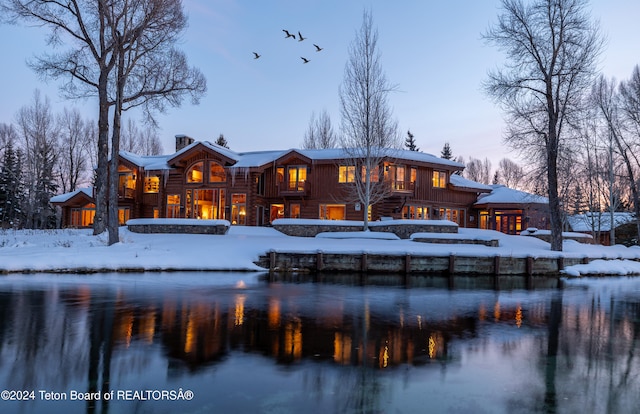 snow covered property featuring a water view