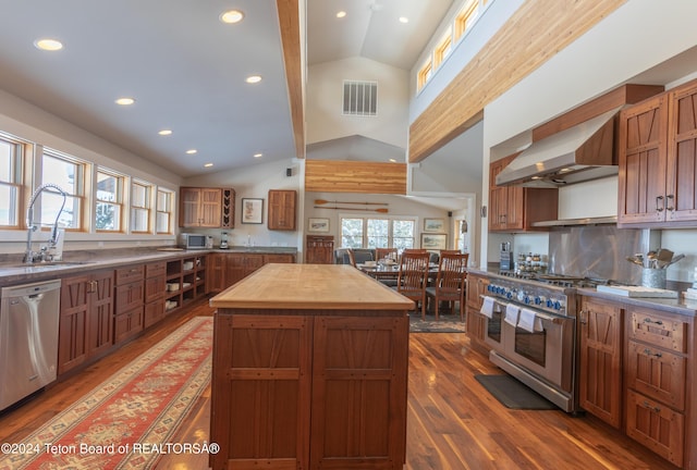 3470 W Mccollister Dr, Teton Village, WY 83025 - kitchen with stainless steel appliances, wood counters, lofted ceiling, wall chimney exhaust hood, and hardwood / wood-style flooring