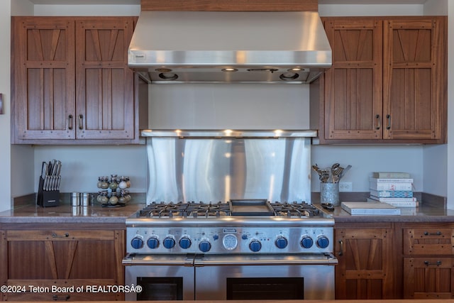 3470 W Mccollister Dr, Teton Village, WY 83025 - kitchen with range hood, range with two ovens, brown cabinetry, and tasteful backsplash
