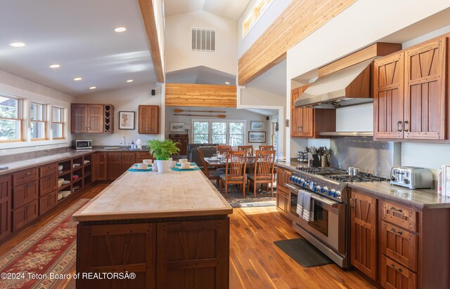 3470 W Mccollister Dr, Teton Village, WY 83025 - kitchen featuring range with two ovens, vaulted ceiling, wood finished floors, a center island, and recessed lighting