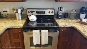 3470 W Mccollister Dr, Teton Village, WY 83025 - kitchen with stainless steel electric range, brown cabinets, and light stone countertops