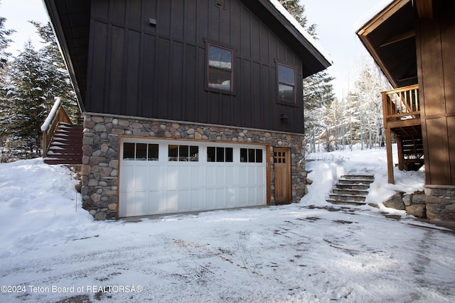 3470 W Mccollister Dr, Teton Village, WY 83025 - snow covered property featuring stone siding, stairs, a garage, and a deck