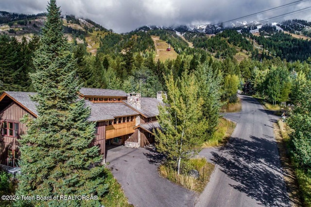 3470 W Mccollister Dr, Teton Village, WY 83025 - view of subject property with a mountainous background and a heavily wooded area