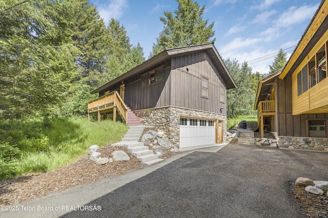 3470 W Mccollister Dr, Teton Village, WY 83025 - view of front of home featuring stairs, stone siding, and asphalt driveway