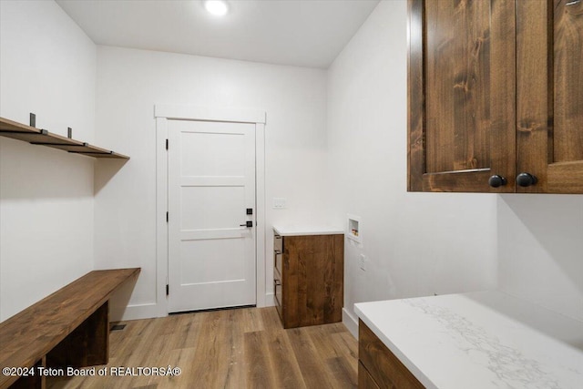 laundry room featuring washer hookup and light hardwood / wood-style flooring