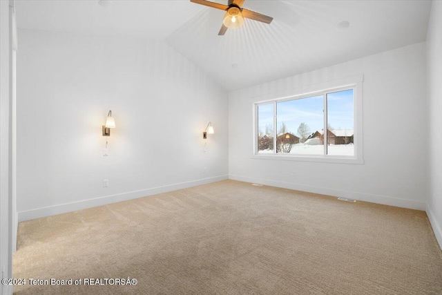 carpeted empty room featuring ceiling fan and vaulted ceiling