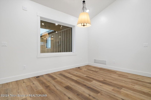 empty room with lofted ceiling and wood-type flooring