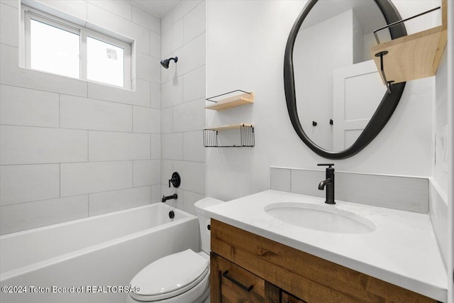 full bathroom featuring toilet, tiled shower / bath, and vanity