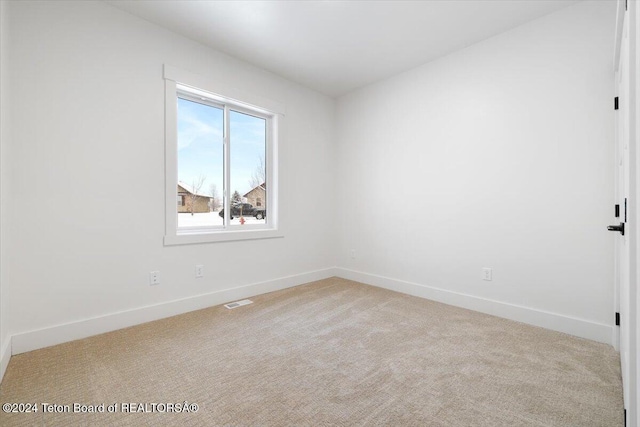 unfurnished room featuring light carpet