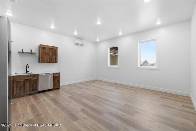 bar featuring dark brown cabinetry, appliances with stainless steel finishes, light hardwood / wood-style floors, sink, and a wall mounted AC