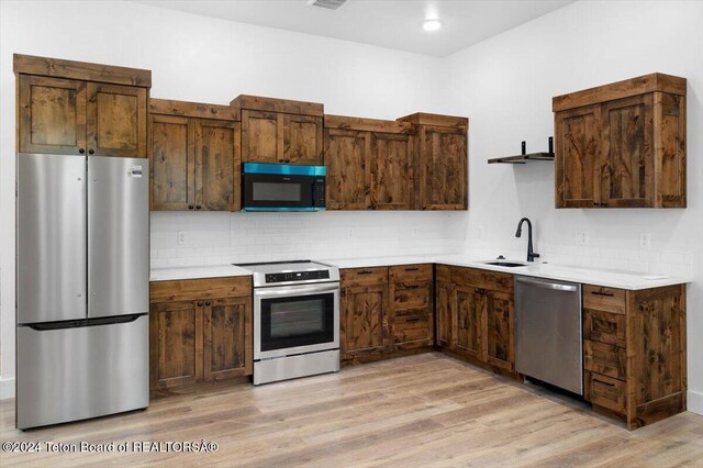 kitchen featuring light wood-type flooring, sink, and stainless steel appliances