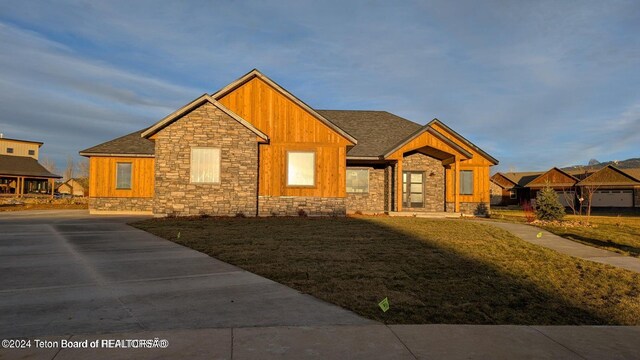 1021 Farmers Trl, Driggs, ID 83422 - craftsman-style home with stone siding, board and batten siding, roof with shingles, and a front lawn