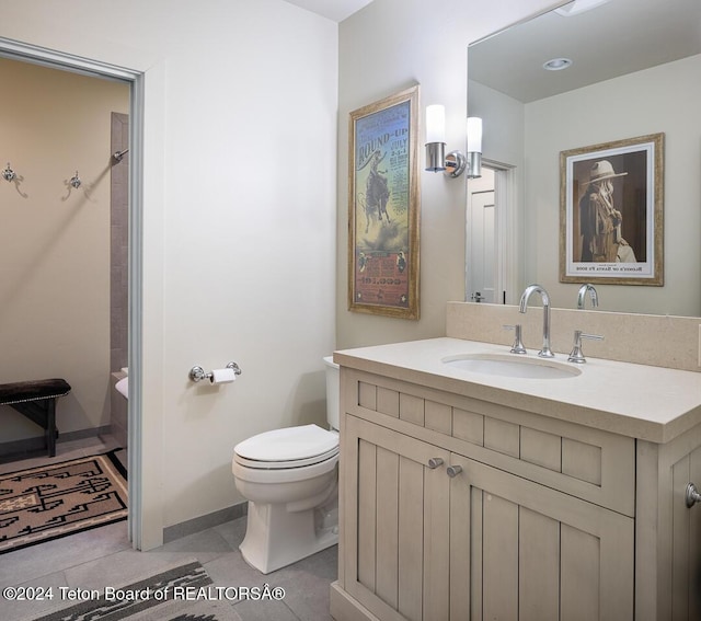 bathroom with tile patterned flooring, vanity, and toilet