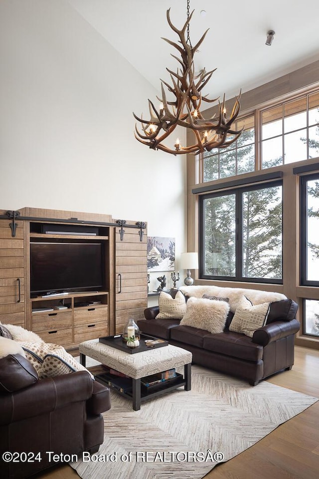 living room with hardwood / wood-style floors, high vaulted ceiling, and a chandelier