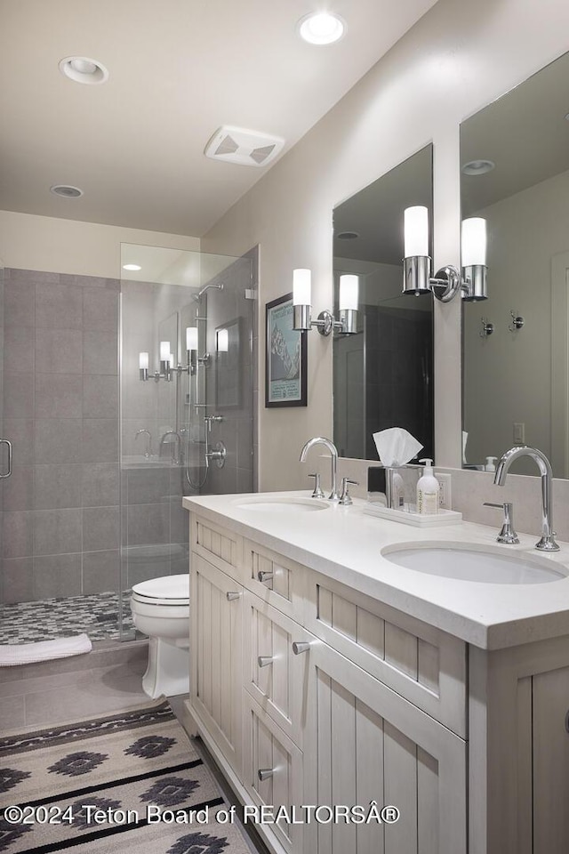 bathroom with tile patterned floors, vanity, toilet, and a shower with door