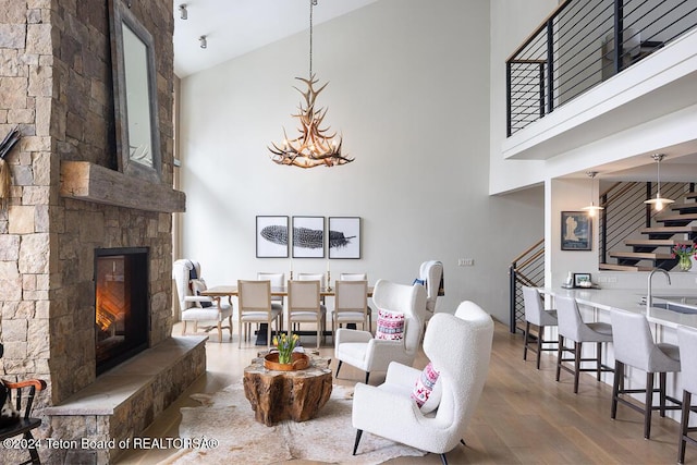 living room with a fireplace, a high ceiling, hardwood / wood-style flooring, and sink