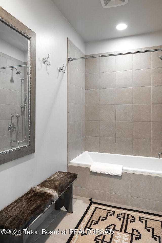 bathroom with tile patterned floors and tiled shower / bath combo