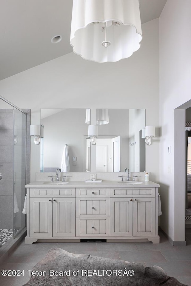 bathroom with vanity, a shower with shower door, and vaulted ceiling