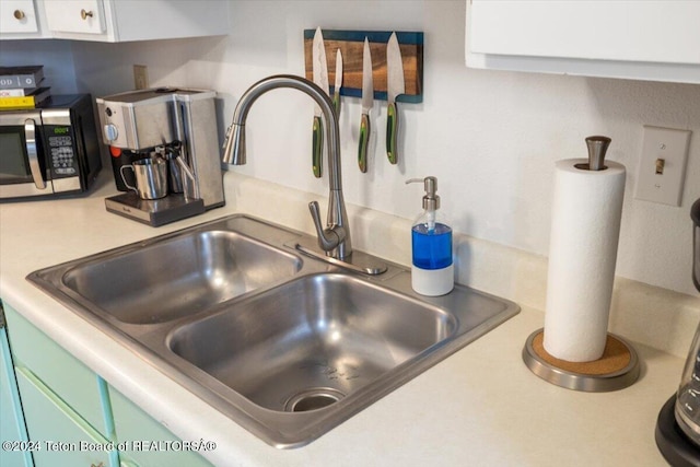 details with green cabinets, white cabinetry, and sink