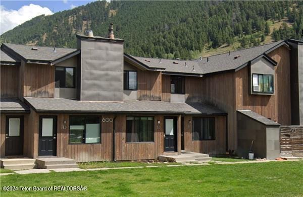 view of front of property with a mountain view and a front yard