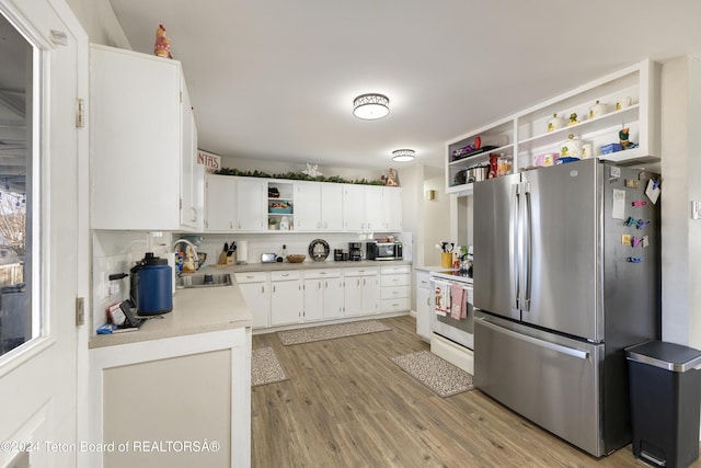 407 N 1st St, Dubois, WY 82513 - kitchen featuring stainless steel appliances, open shelves, light wood-style floors, light countertops, and white cabinetry