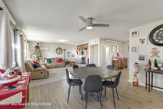 dining room featuring a textured ceiling, light hardwood / wood-style flooring, and ceiling fan