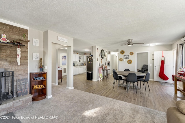 407 N 1st St, Dubois, WY 82513 - dining space with a ceiling fan, a textured ceiling, light wood-style flooring, and light colored carpet