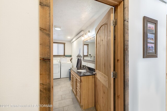 621 Mountain View Dr, Dubois, WY 82513 - bathroom with washing machine and clothes dryer, vanity, tile patterned flooring, and a textured ceiling