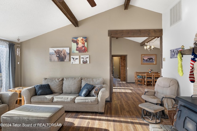 living room featuring ceiling fan with notable chandelier, hardwood / wood-style floors, and vaulted ceiling with beams