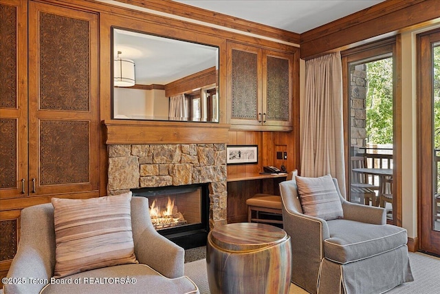 sitting room with carpet floors, a fireplace, and wooden walls