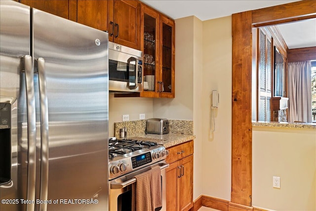 kitchen with light stone countertops and appliances with stainless steel finishes