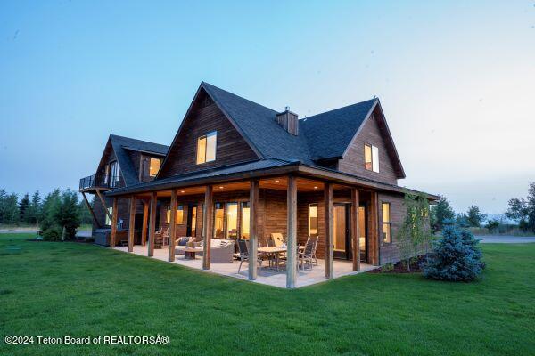 back of house with a lawn and a patio area