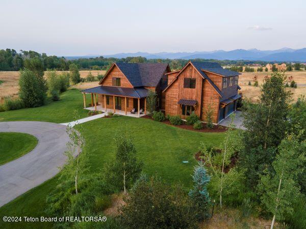 view of front of house with a mountain view, a front lawn, and a porch