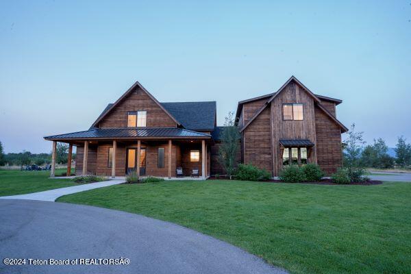 view of front of home with a porch and a front lawn